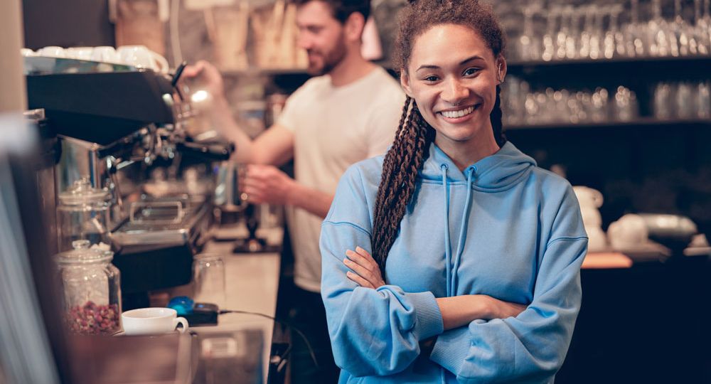 Cafe owner with barista making coffee
